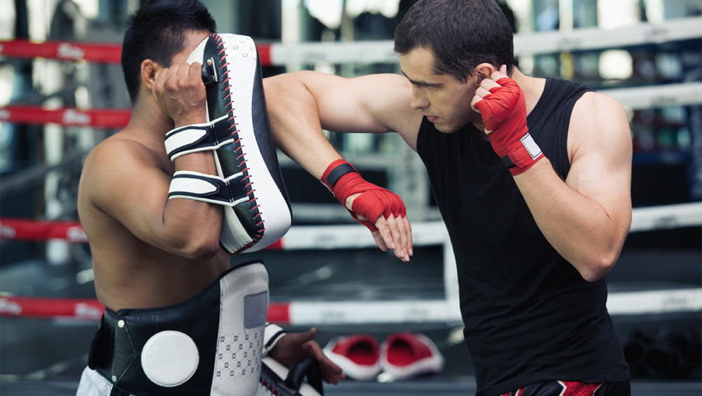 Group of athletes training Muay Thai with trainers in Phuket, Thailand.